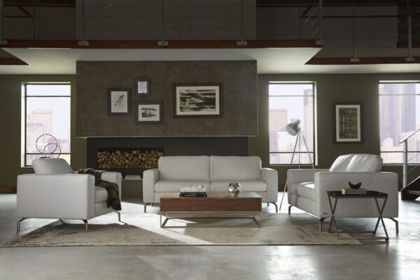 A modern living room featuring the B845 Sollievo Living Room Set by Natuzzi, a central wooden coffee table, and a neutral color palette. The space is accented with framed art on the walls and large windows.